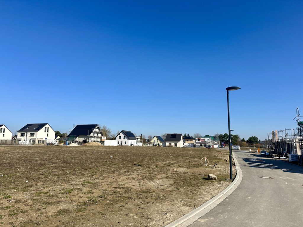 Leeres Grundstück mit neuem Wohngebiet