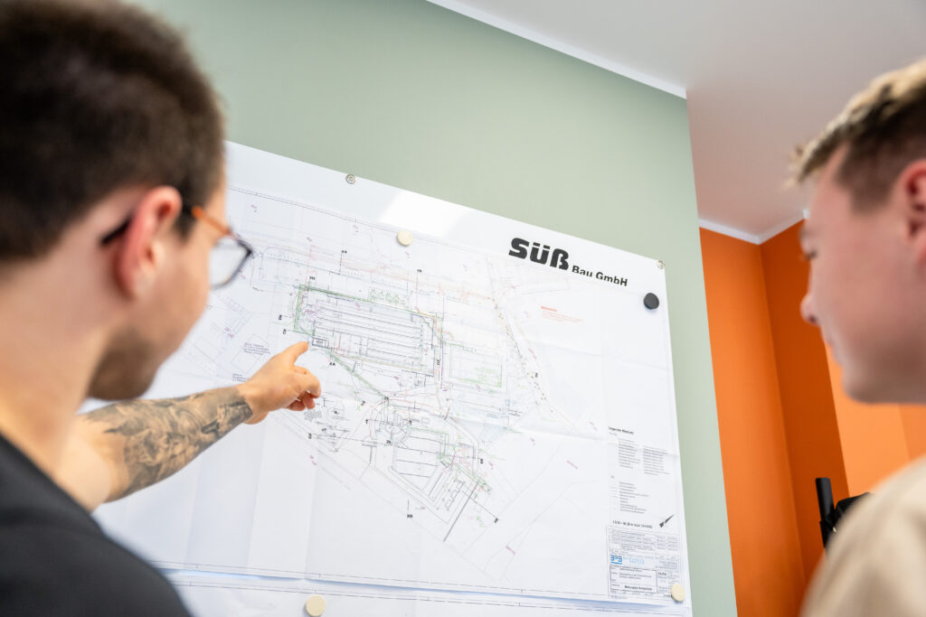 Zwei Personen betrachten einen Bauplan.